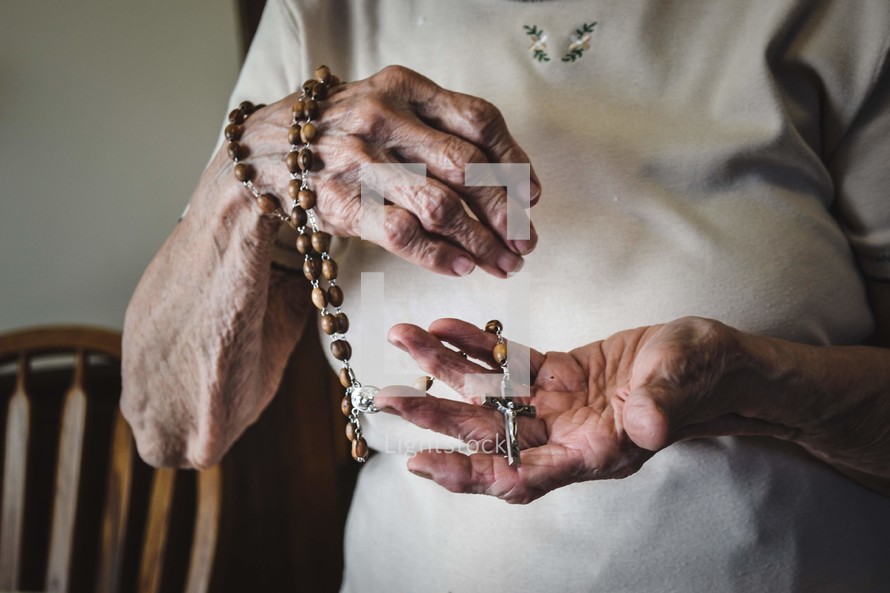 elderly woman holding a rosary 