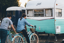 man and woman on bikes in front of a camper 