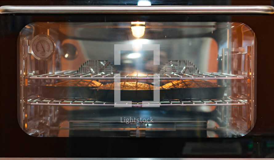 Three carrot cakes in the oven, ambient light.