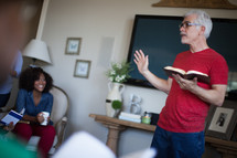 A man teaching a Bible study to a small group of people.