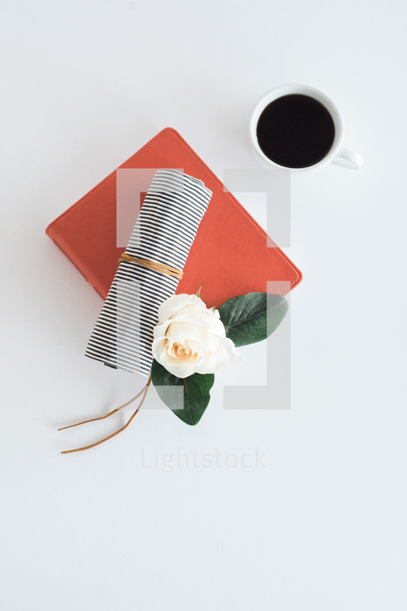 orange journal, rose, pencil case, and coffee mug 