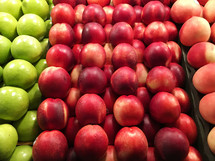 apples and nectarines in a produce section of a market 