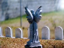 A Guardian angel statue stands guard over a group of children's graves in a cemetary. It is a humbling sight for a parent to have to bury their children but even in death there is victory as the scripture says in 1 Corinthians 15:55- - O death, where is thy sting? O grave, where is thy victory?
