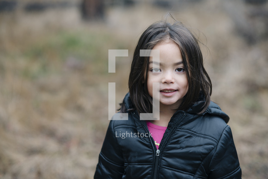 girl child outdoors in a winter coat 