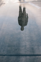 silhouette reflection of a man in a puddle 