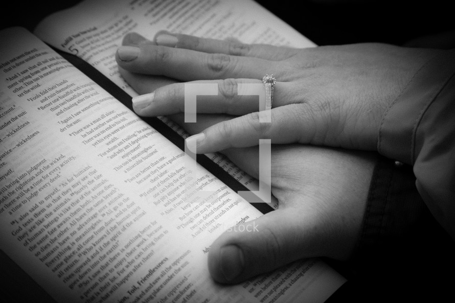 couples hands on a Bible 