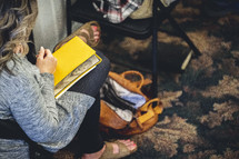 Woman with a yellow Bible on her lap during the church service