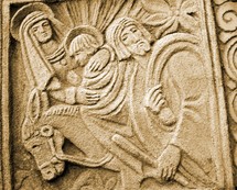 A stone carving of Jesus, Mary and Joseph on a donkey. The artwork is representative of a Mayan or Aztec Indian carved relief depicting a young Jesus travelling with his mother and father through Jerusalem. 