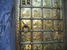 The story of creation from the book of Genesis on a large brass door entrance using panels and engravings to tell the story of Creation from the book of Genesis. 