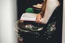 Woman in a church service with a bible on his lap
