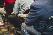 Man reading his Bible during a church service.