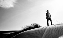 man standing on a sand dune