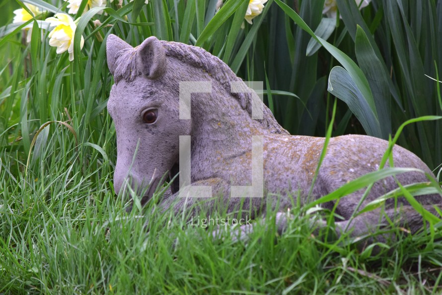 Horse Statue in a flower garden in spring time.