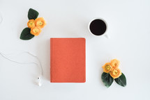 earbuds, journal, yellow roses, and coffee mug 