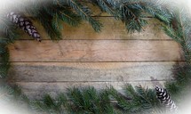 Border of Spruce branches on wooden background with pine cones