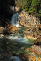 tumbling waterfall flowing into a rocky stream