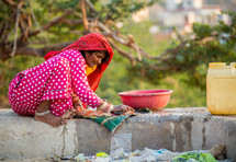a woman washing clothes by hand in India 