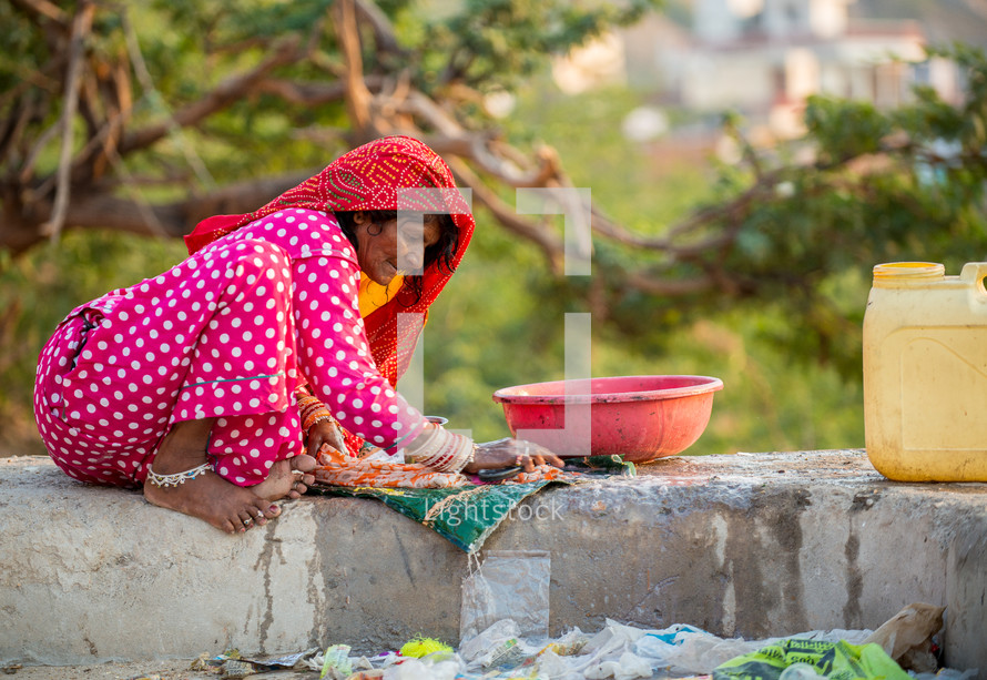 a woman washing clothes by hand in India 