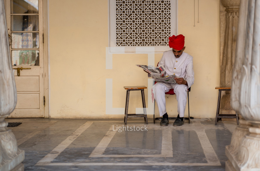 a man in India reading a newspaper 