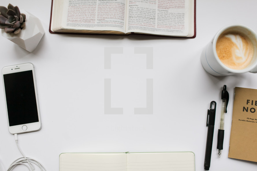 border of Bible study items on a white desk 