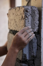 a man laying stone bricks into mortar 