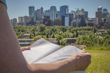 Woman reading a Bible and City Skyline 