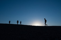 silhouettes of a group of people walking