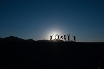 silhouettes of a group of people celebrating 