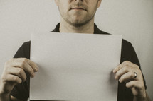 man holding a blank piece of paper 
