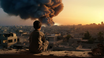Boy watching a large explosion in a Middle Eastern city from a hill. Urban landscape