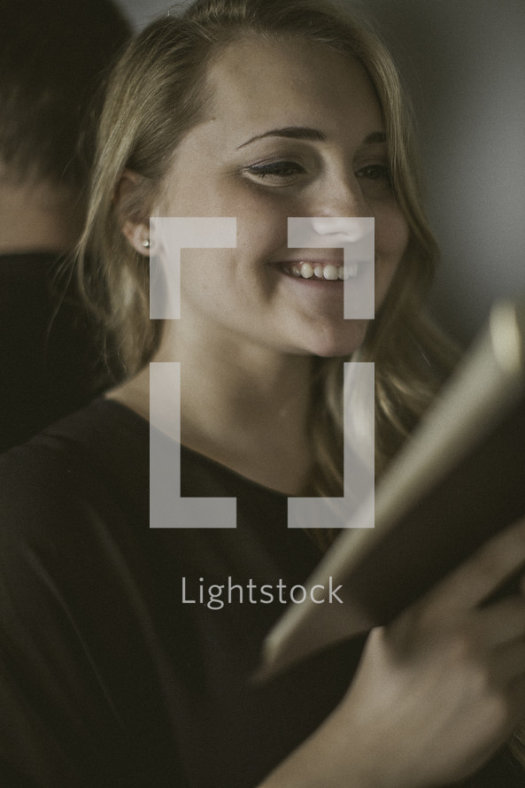 smiling woman reading a Bible 