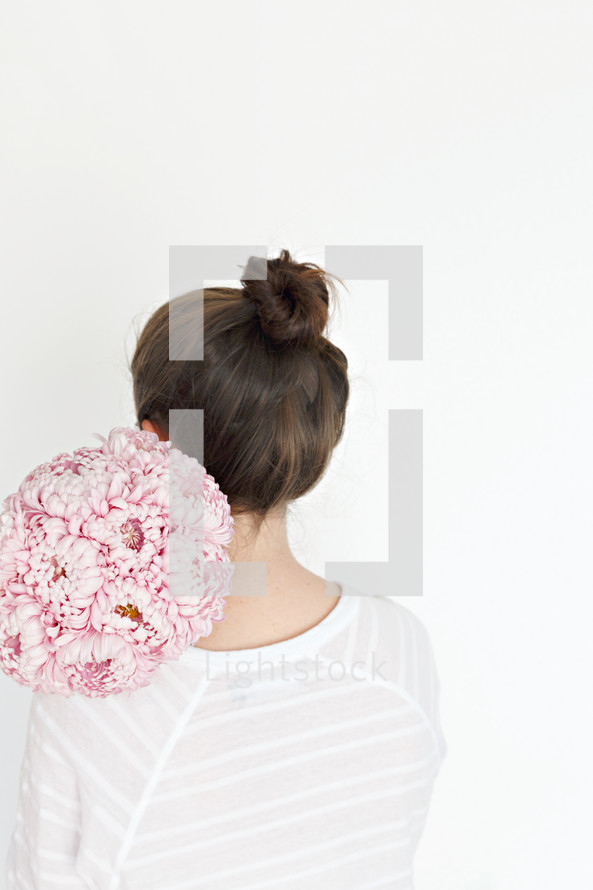 a woman holding a bouquet of flowers over her back 