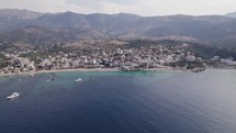 Picturesque coastal town on Albanian Riviera - Himarë, Albania; aerial arc