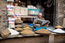 vendor selling spices and grains at a market in India 