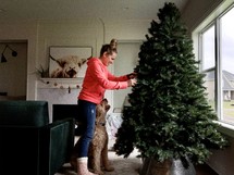 woman decorating a Christmas tree 
