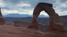 A man hiking to the iconic Delicate Arch in Utah