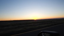Driving POV on a highway at sunrise