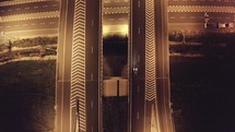 Drone aerial shot of night traffic on a highway showing cars driving and lanes of light with bridges and viaducts