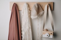 scarves, shawls, hats, and toy camera on hooks 