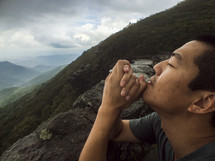 man with praying hands on a mountain top 