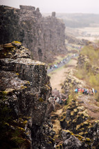 people exploring a paved path along cliffs in Iceland  
