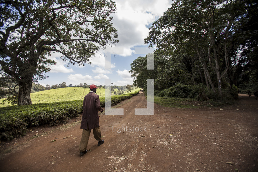 man walking down a dirt road in Africa 