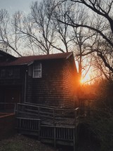 sunset behind a cabin in the woods 
