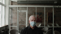 senior male at a restaurant wearing face masks 