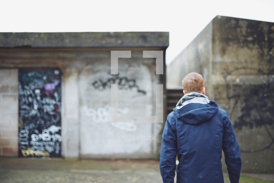 a man standing in front of graffiti covered walls 