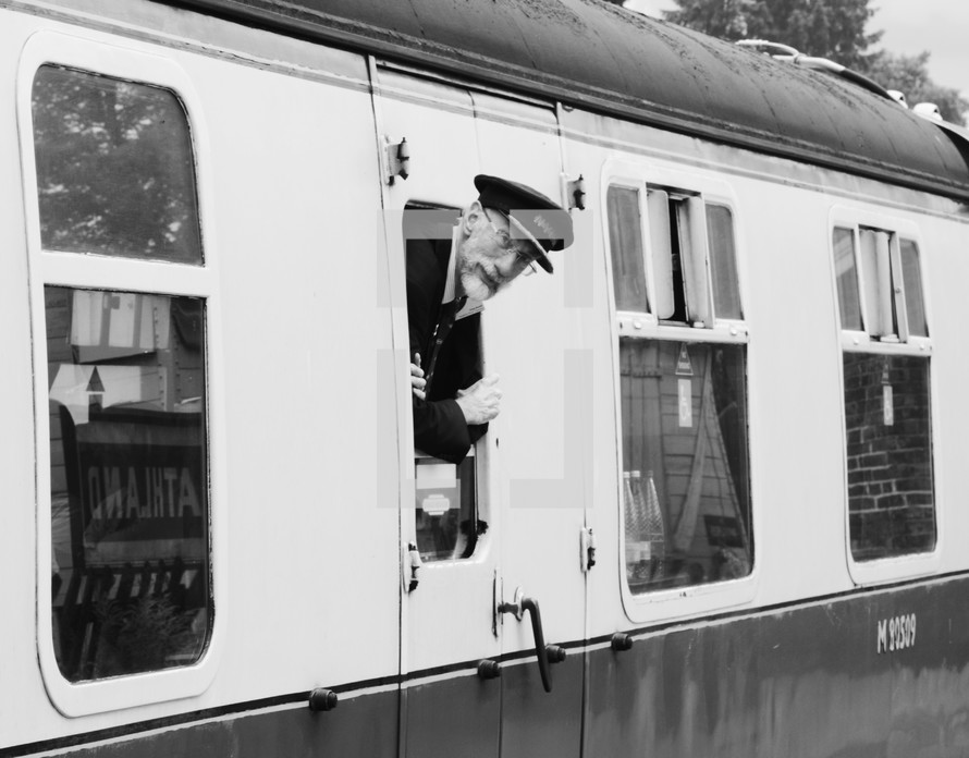 a conductor looking out of a train window 