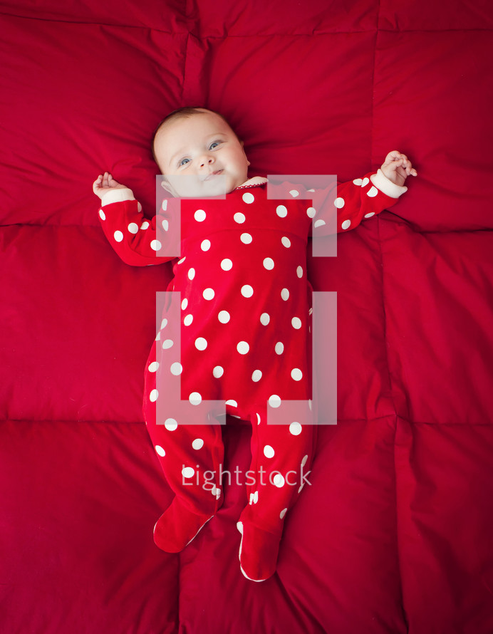 Newborn baby with Christmas suit with polka dot patterned.