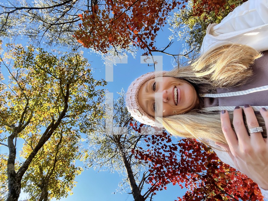 Portrait of a woman in winter hat with autumn trees