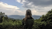 woman looking out at clouds over the Blue Ridge Mountains 