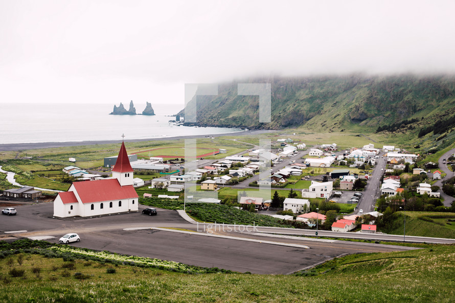 red roof church and homes in a coastal town in Iceland 